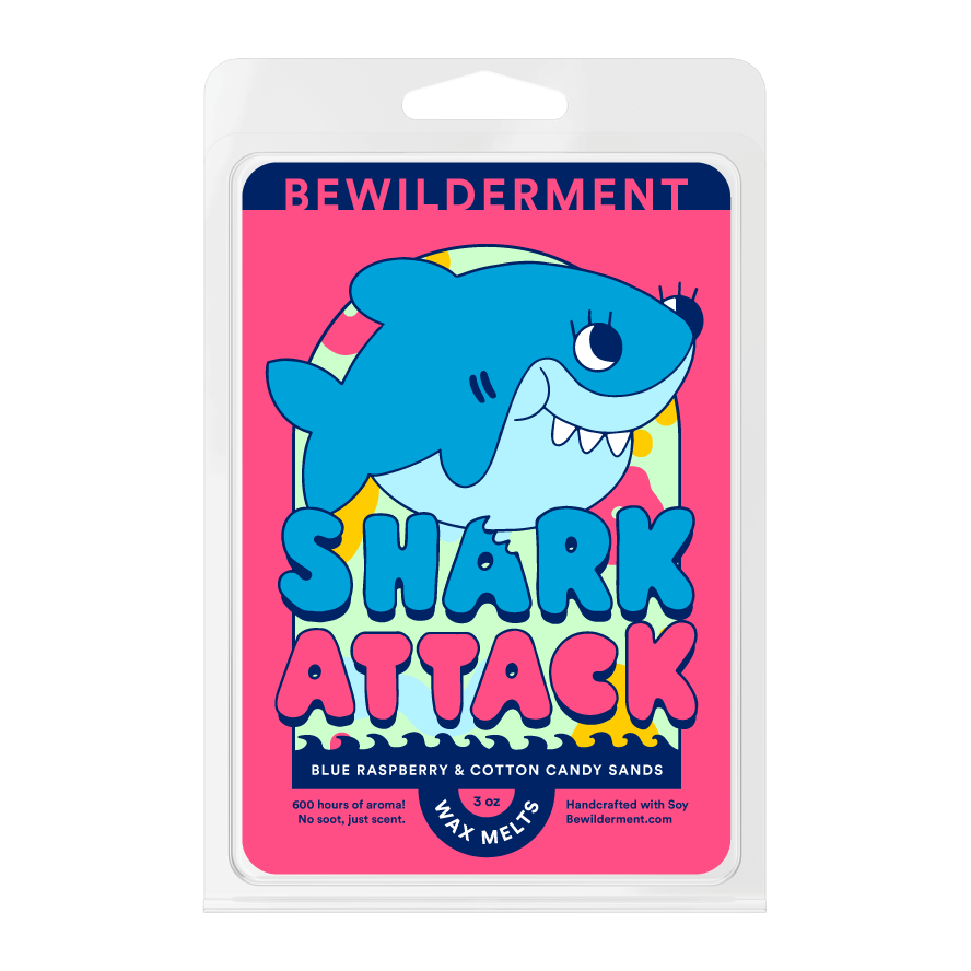 Bright pink wax melt package labeled "Bewilderment Shark Attack" with a cartoon blue shark and colorful text.